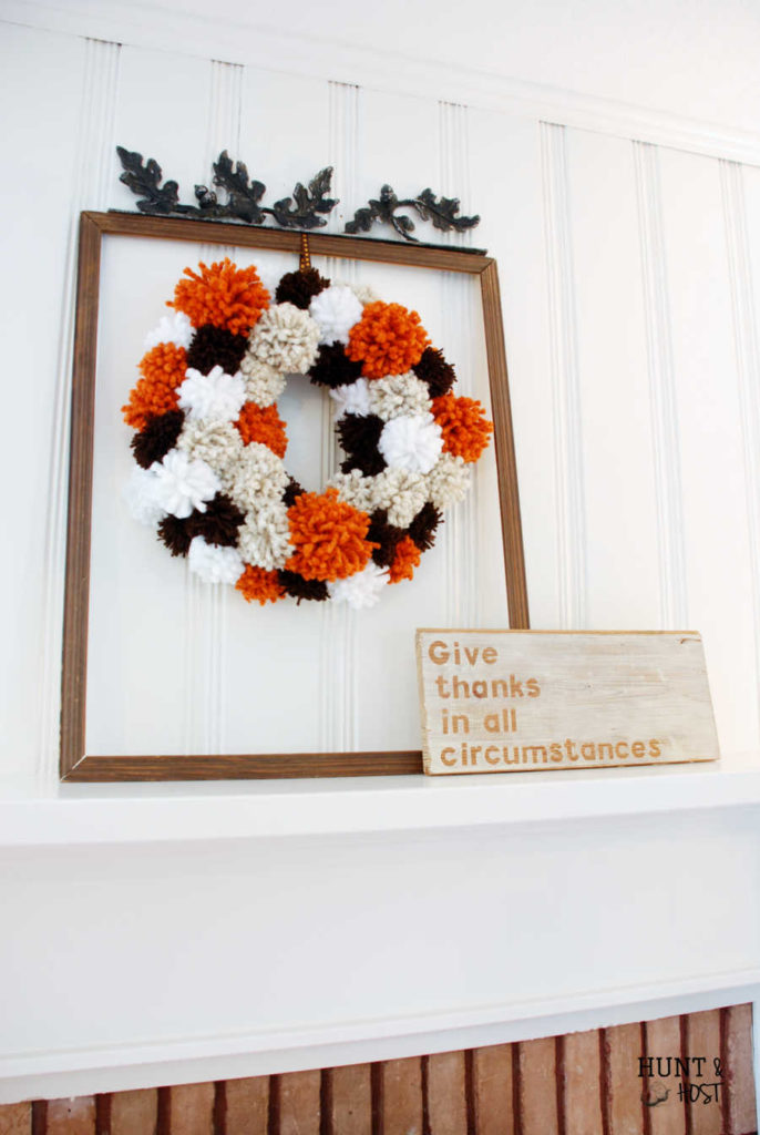 Cozy thoughts happen when you see this DIY Fall pom pom wreath. It's a knock out in stunning Autumn colors!
