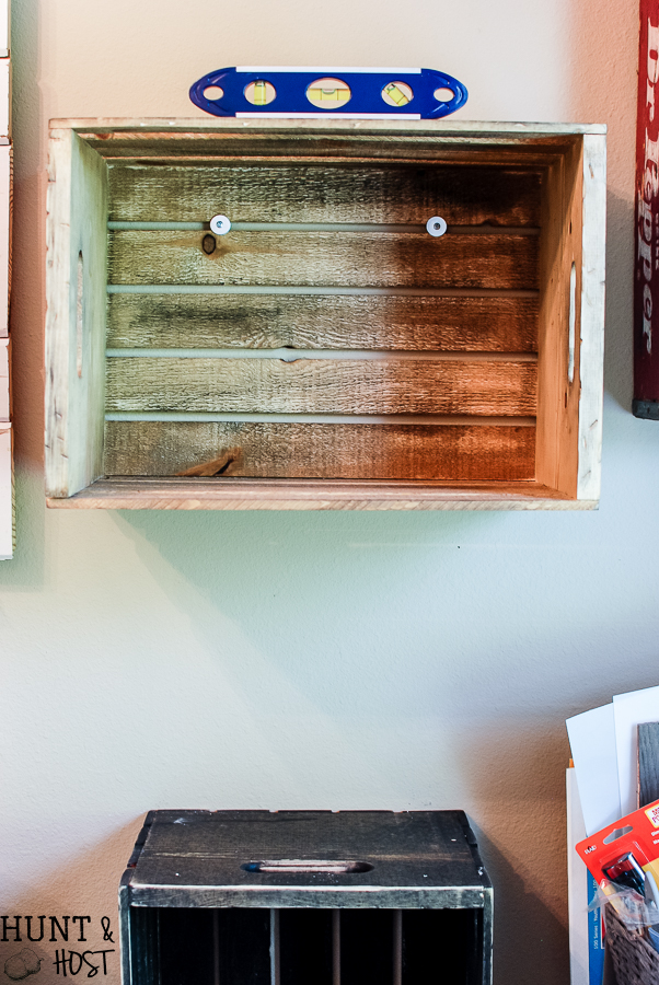 New crates get an old makeover with stain and stencils. Great for extra storage and organizing see an easy tip on how to hang crates without damaging them while still having them sturdy and straight.
