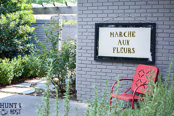 Get a vintage French feel with this DIY hand painted glass sign tutorial. The French flower market sign looks great on a patio or as large wall art. Marche Aux Fleurs!