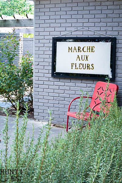 Get a vintage French feel with this DIY hand painted glass sign tutorial. The French flower market sign looks great on a patio or as large wall art. Marche Aux Fleurs!