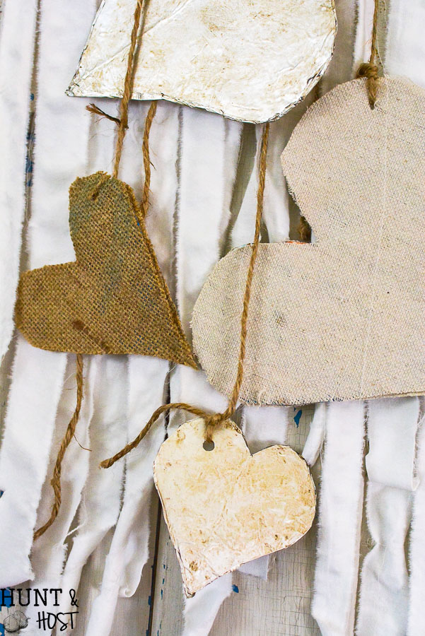 Create boho chic wall hanging decor from your old linens. Purging the linen closet will provide tons of great crafting material. This DIY wall hanging is dressed up for Valentine's Day, but would be great for a farmhouse feel any time of year. WIth great texture from burlap, drop cloth and tin foil this tone on tone neutral decor is a versatile addition to any style, Simple natural touches round out this Valentine home tour. 