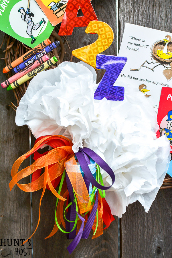 Need a fun teacher appreciation gift idea? This DIY teacher wreath is sure to be a hit, made from all the school supply leftovers, game pieces and miscellaneous office supplies show your favorite teacher some love with cute classroom decor!