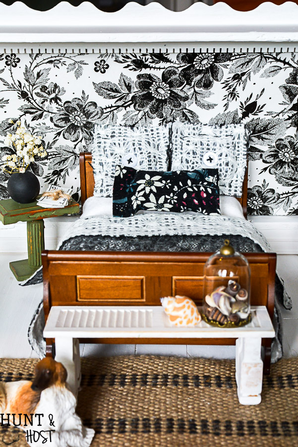 Get lost in in cozy comfort with these dollhouse master bedroom decor ideas. Large scale floral wallpaper make the room a dramatic room with vintage touches, you'll seriously want to move into this dollhouse bedroom! Vintage clocks on the fireplace mantel with a dramatic black and white theme.