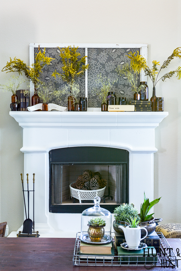Decorating the mantel for fall with amber glass jars and roadside dreid flowers.
